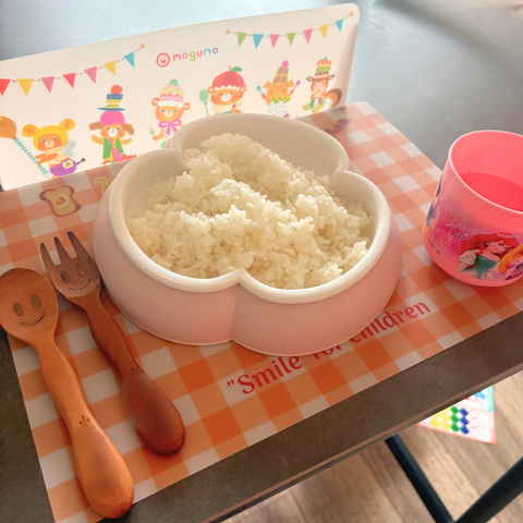モグモのキャラクター入りランチョンマットに、ご飯と子ども用の食器を並べた食卓。